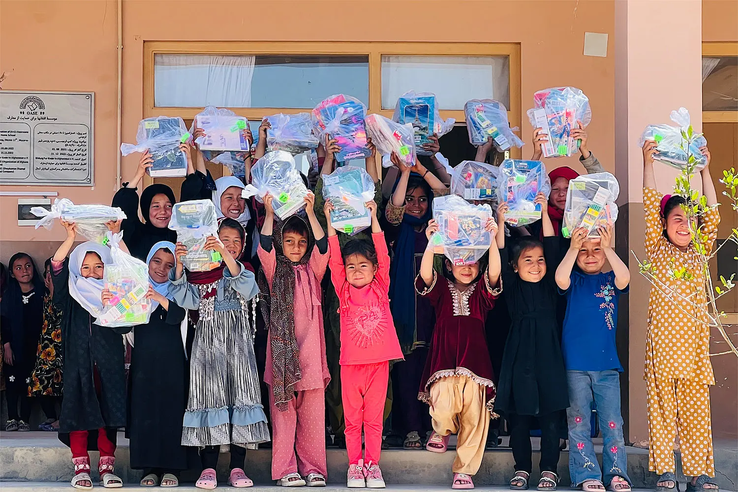 Kinder halten ihre neuen Schulranzen in die Luft