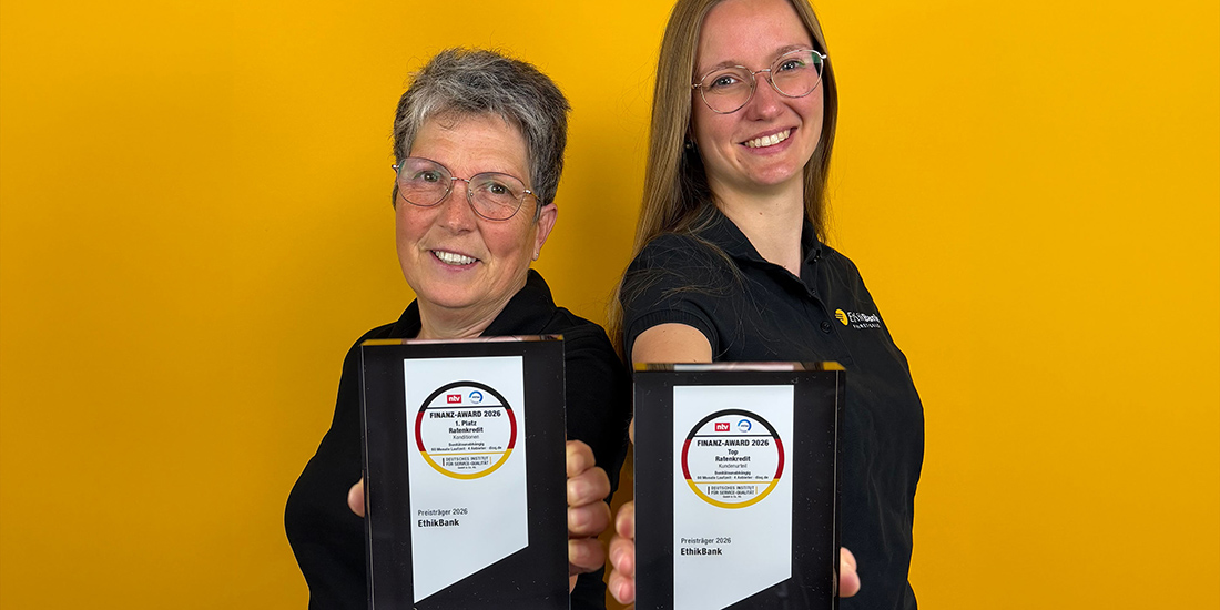 Zwei EthikBank-Mitarbeiterinnen halten lächelnd die zwei Finanz-Awards in die Kamera